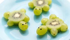 grapes and kiwis are arranged on a plate with one cut in the shape of a turtle