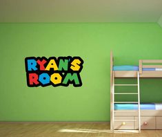 a green room with bunk beds and a wooden ladder on the floor in front of it that says ryan's room