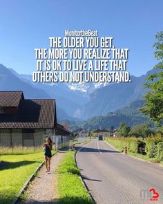 a person walking down a road with mountains in the background and a quote on it