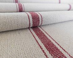 three red and white striped rugs are stacked on top of each other in rows