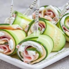 there are many different types of food on this white plate, including cucumbers and ham