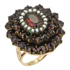 This stunning vintage cluster ring, it is crafted from solid 14k yellow gold with fancy scroll engraving around the shank and shoulders. The large oval top platform has a three tier step, the top center has an oval cut garnet surrounded with seed pearls and the lower two tiers are prong set round cut garnets. The ring comes with a sizer on the inside for a smaller finger size 4.     Material:  14k yellow gold  Measurement: Top size: 26mm long x 23mm wide x 11mm high  Ring Size: 4    12mm across Victorian Oval Ruby Ring, Antique Oval Multi-stone Ring, Antique 14k Gold Oval Cluster Ring, Antique Oval Cluster Ring In 14k Gold, Heirloom Style Oval Ring For Vintage Events, Antique Multi-stone Cluster Ring For Formal Occasions, Antique Oval Yellow Gold Cluster Ring, Vintage Oval Cluster Ring For Formal Occasions, Victorian Cluster Ring In 14k Gold, Oval Shaped