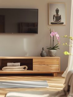 a living room scene with focus on the entertainment center and flowers in front of the flat screen tv