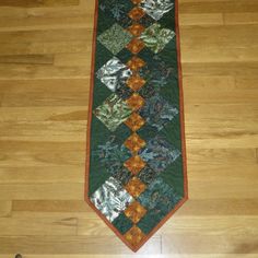 a green and orange tie sitting on top of a wooden floor