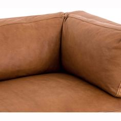 a brown leather couch with two pillows on the back and one arm folded over it