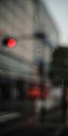 rain drops on the window as cars drive by