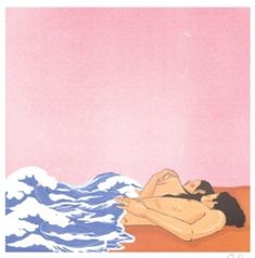 a woman laying on top of a beach next to the ocean under a pink sky