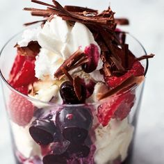 an ice cream sundae with berries and chocolate shavings