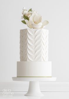 a white wedding cake with flowers on top