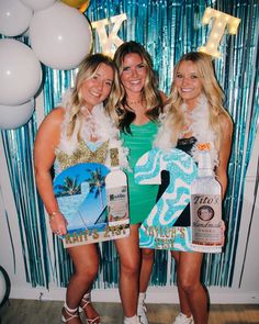 two women standing next to each other in front of a party wall with balloons and streamers