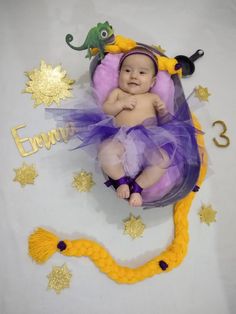 a baby is wearing a purple and yellow costume