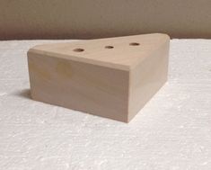 a wooden block sitting on top of a white surface