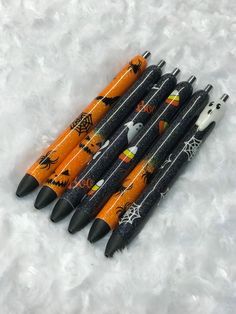 six halloween themed pens lined up in a row on top of white snow covered ground