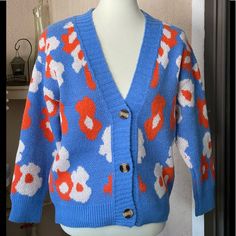 Soft Blue Cardigan With Orange & White Flowers. 100% Polyester. Blue Casual Floral Print Outerwear, Casual Blue Floral Print Outerwear, Trendy Blue Spring Cardigan, Spring Blue Floral Print Cardigan, Orange Floral Print Outerwear For Fall, Blue Floral Print Fall Outerwear, Orange White Flowers, Alpaca Cardigan, Embellished Cardigan