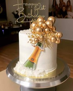 a birthday cake decorated with champagne and gold balloons