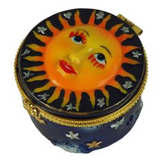 a small blue box with a yellow sun face on the lid and stars around it