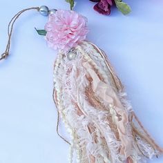 a piece of fabric with flowers on it and some beads hanging from the end of it