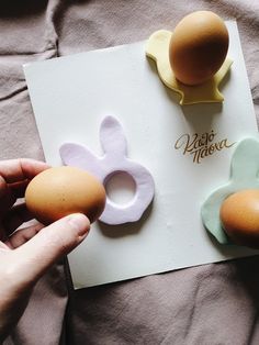 someone is holding two eggs in front of an easter card