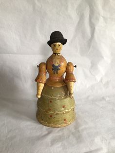 a small wooden figurine sitting on top of a white sheet