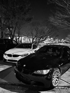 two cars parked in front of each other on the side of a road at night