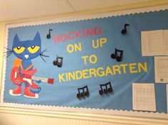 a bulletin board with music notes on it and a cat playing an electric guitar in front of the caption reading rocking on up to kindergarten