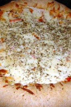 a pizza with cheese and seasoning on it