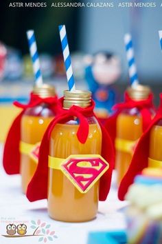 four mason jars filled with peanut butter and topped with superman's cape