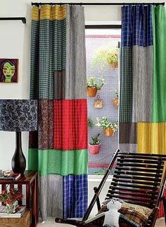 a chair sitting in front of a window with colorful curtains on the windowsills