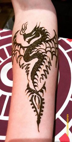 a woman's arm with a dragon tattoo on it