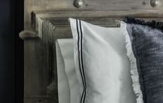 three pillows are lined up on a wooden headboard