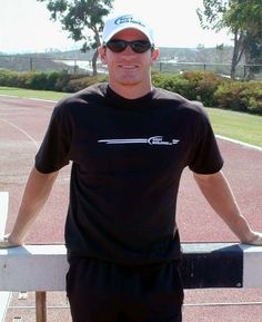 a man standing on a tennis court with his arms crossed