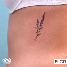 a woman's stomach with a small tattoo of lavender flowers on the lower side