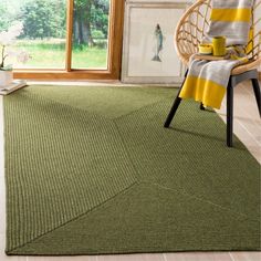 a green rug in a room with a chair