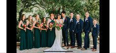 a group of people standing next to each other in front of trees and flowers on the ground