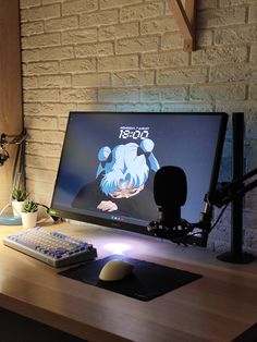 a computer monitor sitting on top of a wooden desk next to a keyboard and mouse