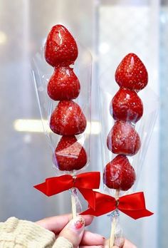 strawberries are wrapped in cellophane and tied with red ribbon to look like candy