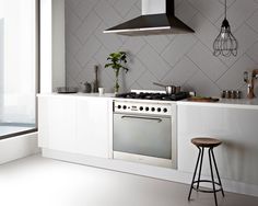 a stove top oven sitting inside of a kitchen next to a window and countertop