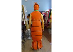 an inflatable orange fish costume is standing next to clothes on racks and shelves