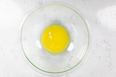 an egg in a glass bowl on a white counter