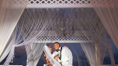 a man and woman standing under a white canopy