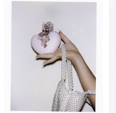 two pictures of a woman's hand holding a pink ornament in front of her face