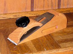 a knife sharpener sitting on top of a wooden table next to a wood paneled wall