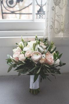 a bouquet of flowers sitting on top of a table next to a window sill