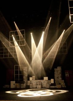 three spotlights are shining in the middle of a stage with white circles on it