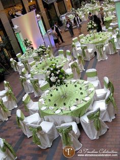 tables and chairs covered in white and green linens