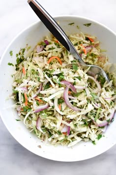 a white bowl filled with coleslaw and carrots