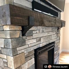 a stone fireplace with a flat screen tv mounted on it's wall above the mantle