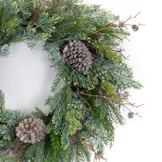 a wreath with pine cones and evergreen needles