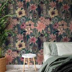 a bedroom with floral wallpaper and a plant in the corner next to the bed