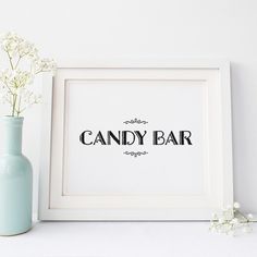 there is a vase with flowers in it next to a candy bar sign